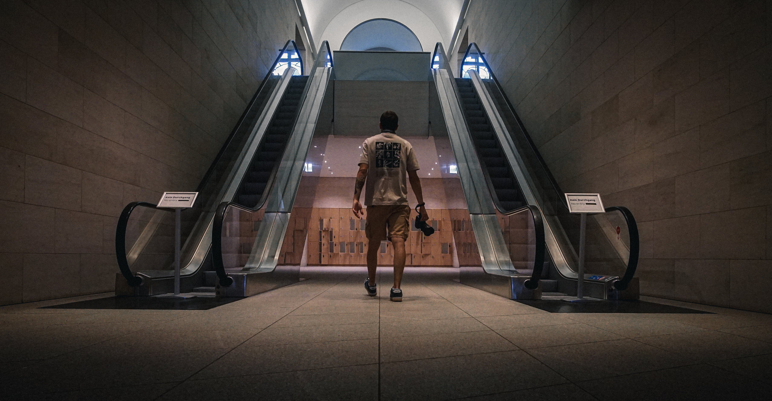 Fotografierender vor zwei aufwärts fahrenden Rolltreppen